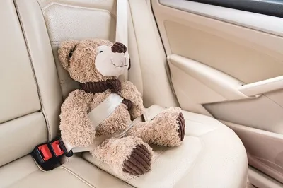 Kinderspielzeug ist im Auto festgeschnallt.