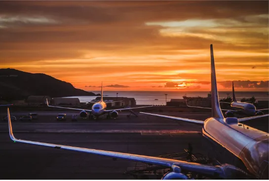 Flugzeug auf dem Hintergrund des Meeres und des Sonnenuntergangs