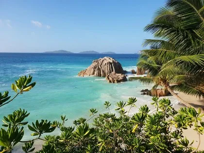 Granitfelsen und türkisfarbenes Wasser an einem Strand auf den Seychellen